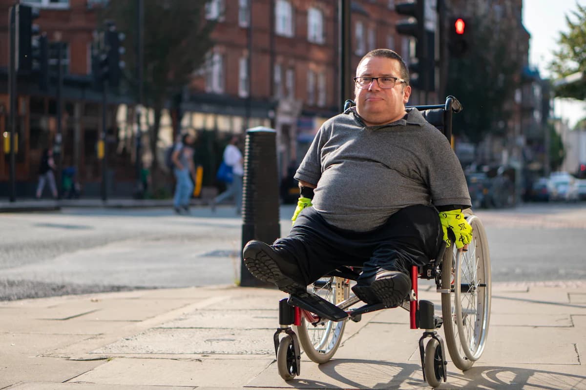 A man moving along a path in a wheelchair.